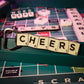 Scrabble™ - Magnetic CHEERS Bottle Opener